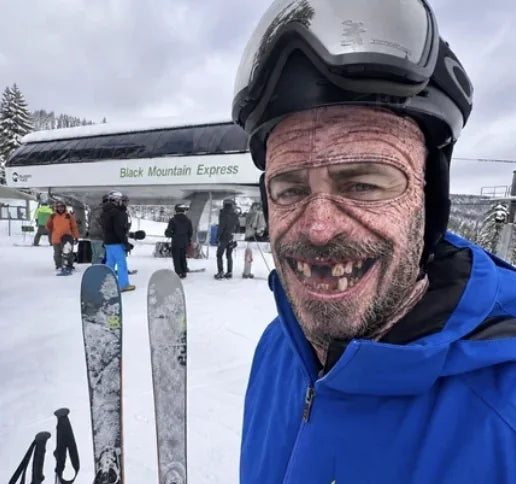 Skier wearing funny realistic elderly face ski mask